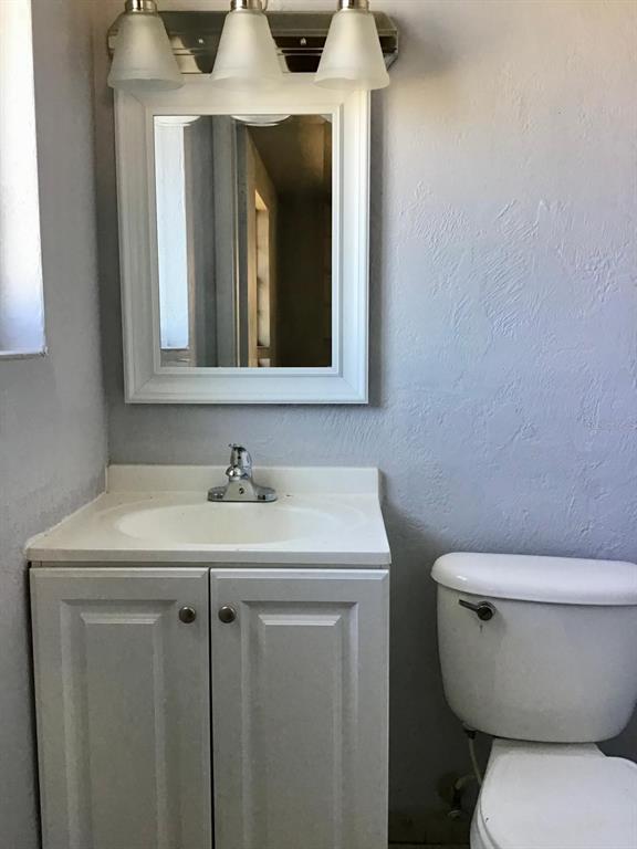 854 Derbyshire Road Daytona Beach, FL 32117 - Photo 5 of 12 a bathroom with a toilet sink and mirror
