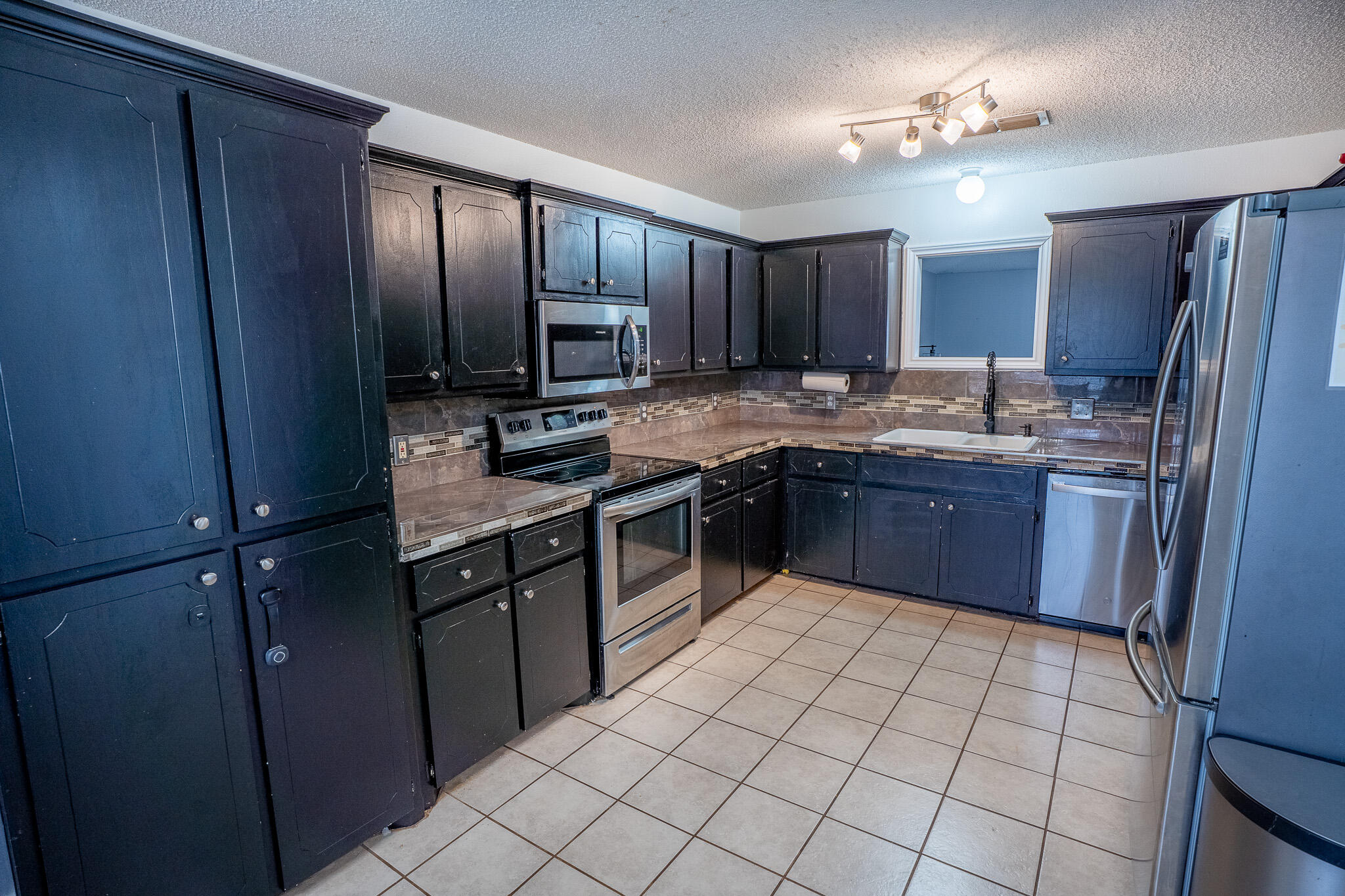 1609 78th Street Lubbock, TX 79423 - Photo 7 of 36 a kitchen with stainless steel appliances granite countertop a sink stove and refrigerator