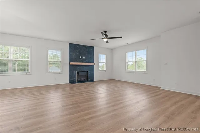 an empty room with windows and a fireplace