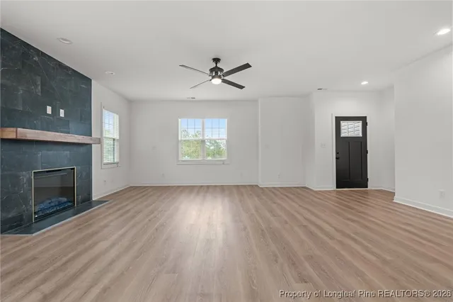 an empty room with windows and fireplace