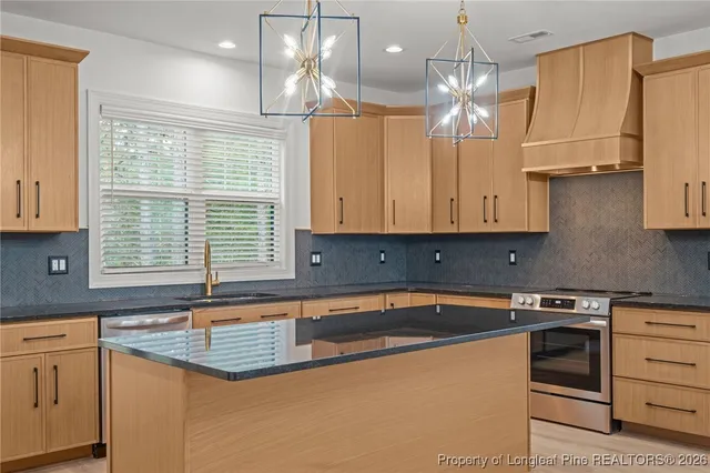 a kitchen that has a sink a stove and cabinets