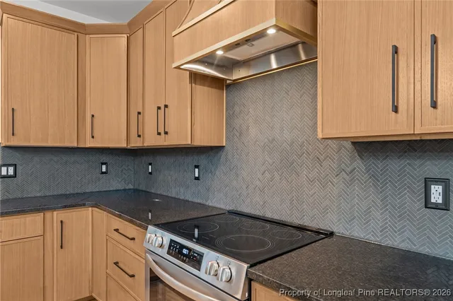 a kitchen with granite countertop a stove and cabinets