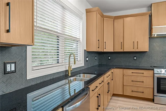 a kitchen with granite countertop white cabinets and sink