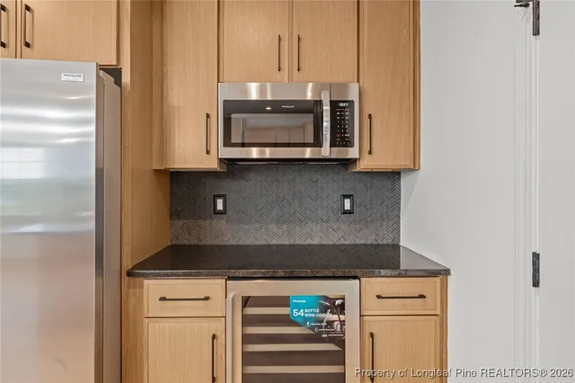 a kitchen with stainless steel appliances granite countertop white cabinets and a stove
