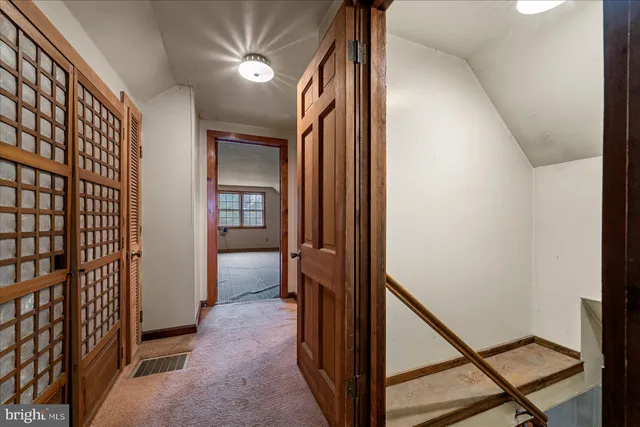 a view of an empty room with window and stairs