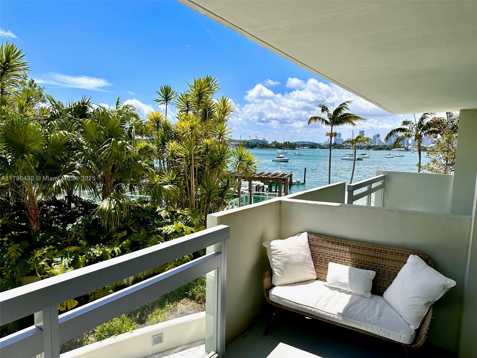 1500 Bay Road, Unit 234S Miami Beach, FL 33139 - Photo 1 of 34 a view of a balcony with wooden floor and outdoor seating