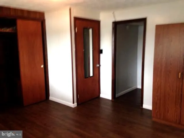 an empty room with wooden floor and closet