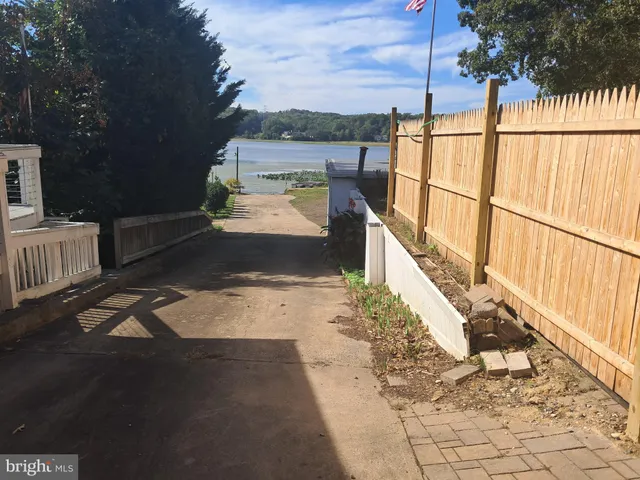 a view of a pathway of a house with wooden fence