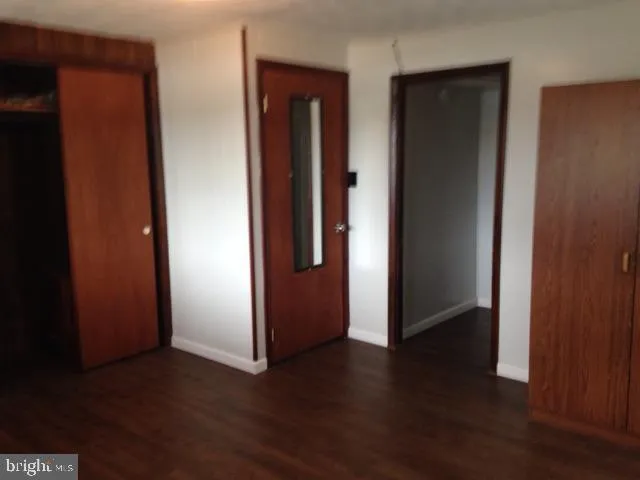 an empty room with wooden floor and closet