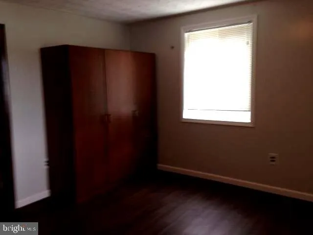 an empty room with wooden floor and a window