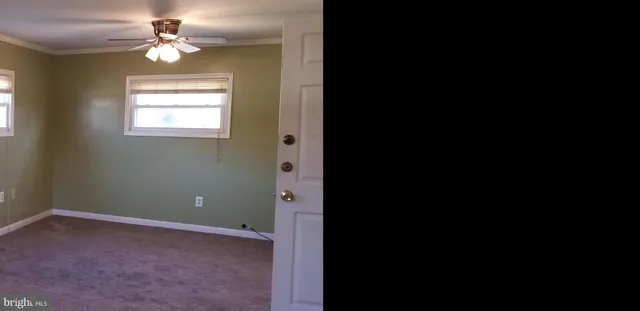 a view of a room with a ceiling fan and a window
