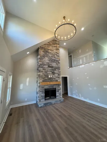 an empty room with wooden floor fireplace and window