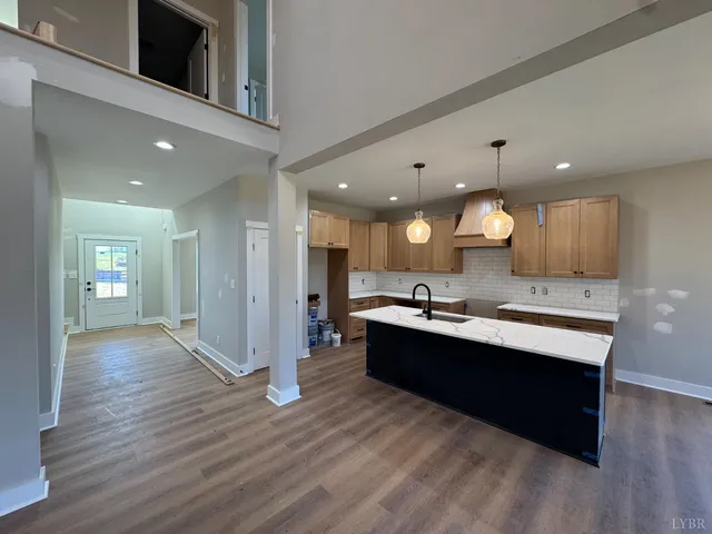a view of a kitchen with kitchen island a sink stainless steel appliances and cabinets