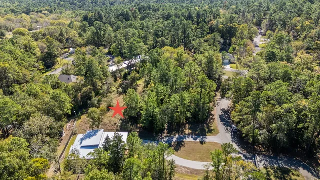 an aerial view of residential house with outdoor space and trees all around