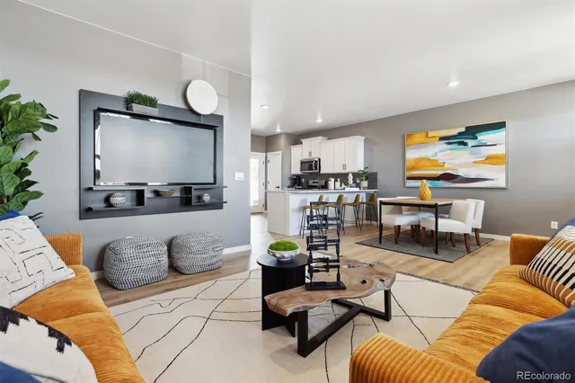 a living room with furniture kitchen view and a flat screen tv