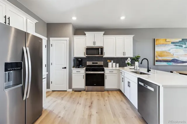 a kitchen with granite countertop a refrigerator stove and sink
