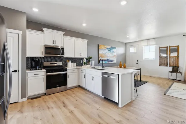 a kitchen with white cabinets and stainless steel appliances