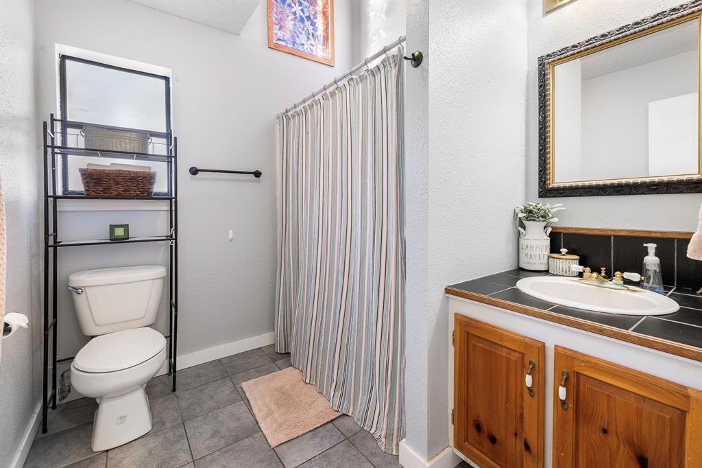 401 Sandy Lane Dublin, TX 76446 - Photo 20 of 39 a bathroom with a toilet a sink and a mirror