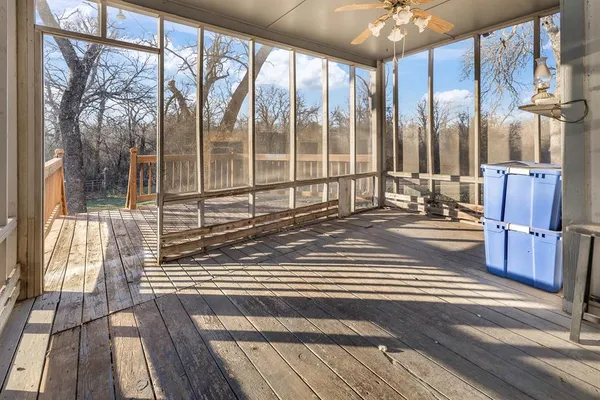 a view of balcony with wooden floor and fence and a large window