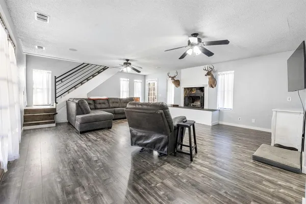 a living room with furniture and a wooden floor