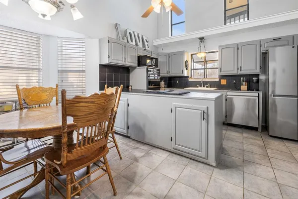 a kitchen with stainless steel appliances granite countertop a stove a sink a dining table and chairs