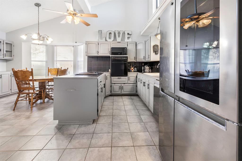 401 Sandy Lane Dublin, TX 76446 - Photo 9 of 39 a large white kitchen with cabinets a sink a stove a dining table and chairs