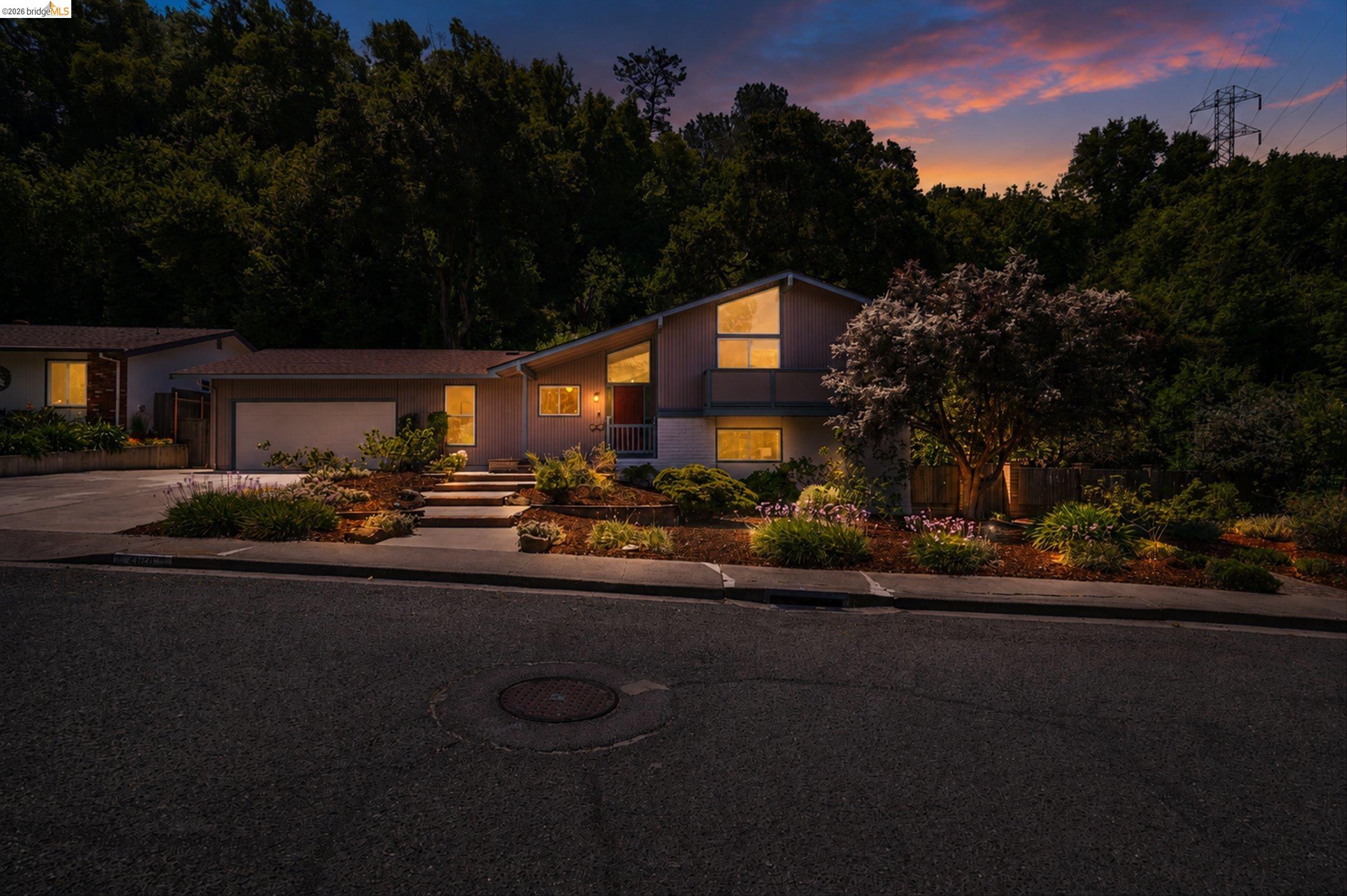 2826 Wright Avenue Pinole, CA 94564 - Photo 2 of 70 Split-level home featuring an attached garage, landscaped front yard with mature trees, and a concrete driveway