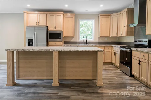 a kitchen with stainless steel appliances granite countertop a stove a sink and a microwave