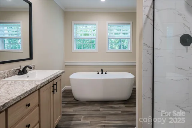a bathroom with a granite countertop tub sink and mirror