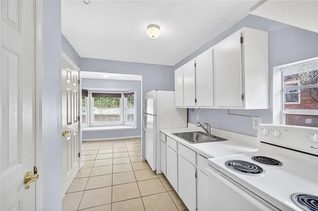 a kitchen that has a sink cabinets counter space and appliances