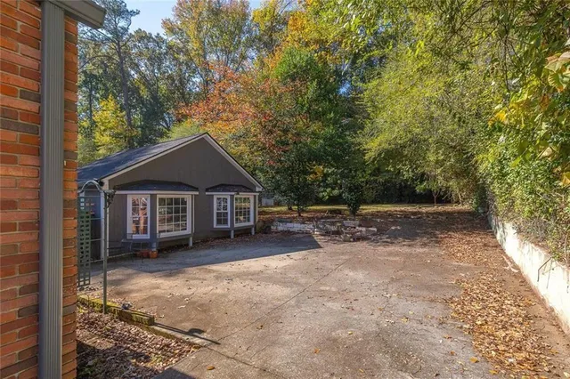 a view of a house with a yard and large tree