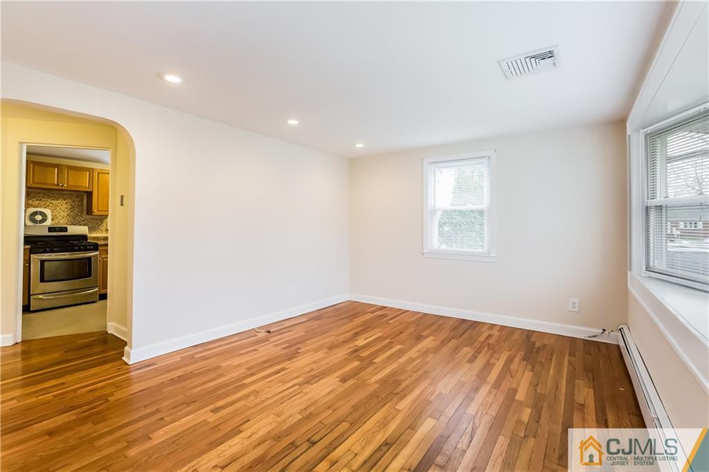 41 West Cliff Road Colonia, NJ 07067 - Photo 2 of 23 an empty room with wooden floor cabinet and windows