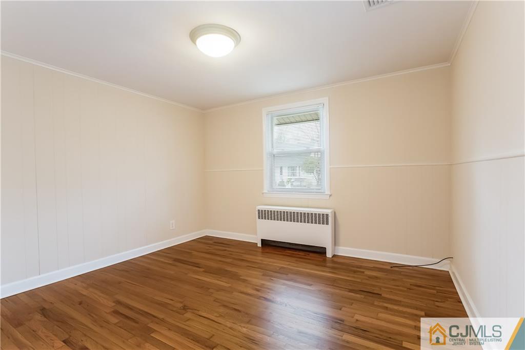 41 West Cliff Road Colonia, NJ 07067 - Photo 3 of 23 an empty room with wooden floor and windows