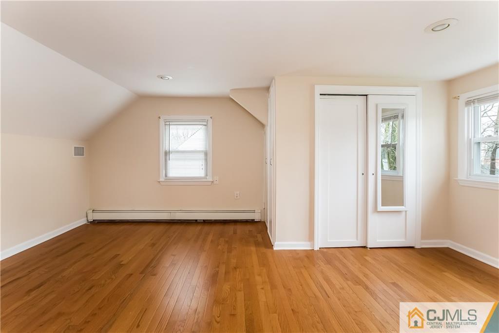 41 West Cliff Road Colonia, NJ 07067 - Photo 21 of 23 an empty room with wooden floor and windows