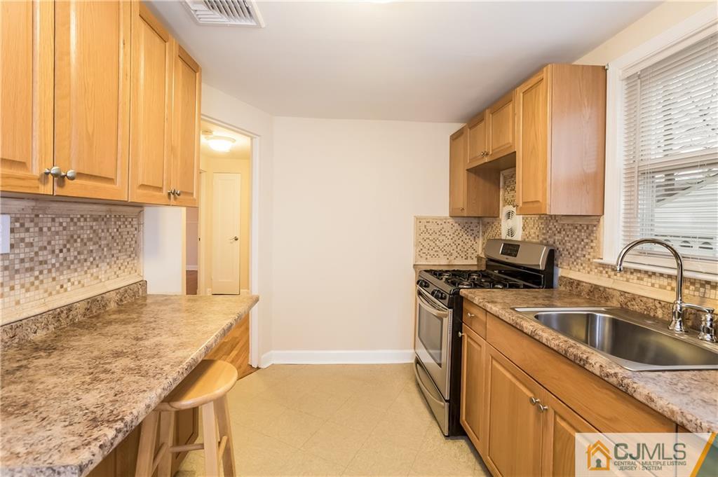 41 West Cliff Road Colonia, NJ 07067 - Photo 7 of 23 a kitchen that has a sink a stove and a window