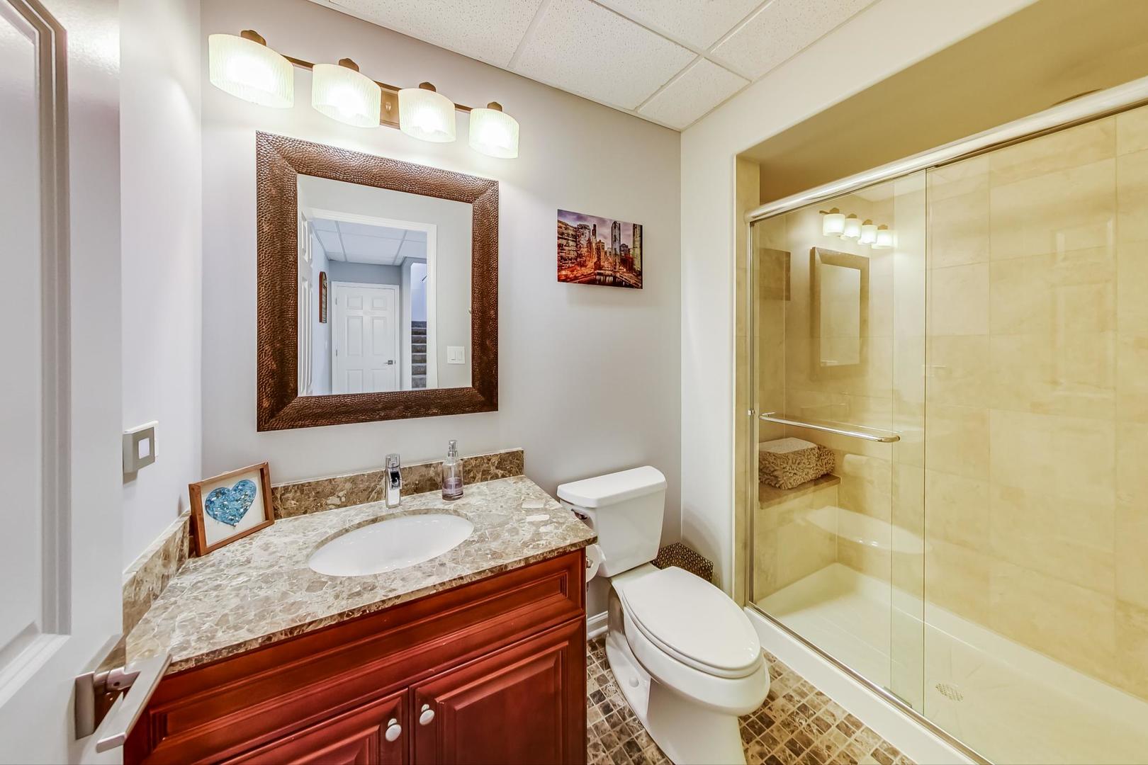 1415 Rue Paris Place Inverness, IL 60067 - Photo 28 of 35 a bathroom with a granite countertop sink toilet and shower