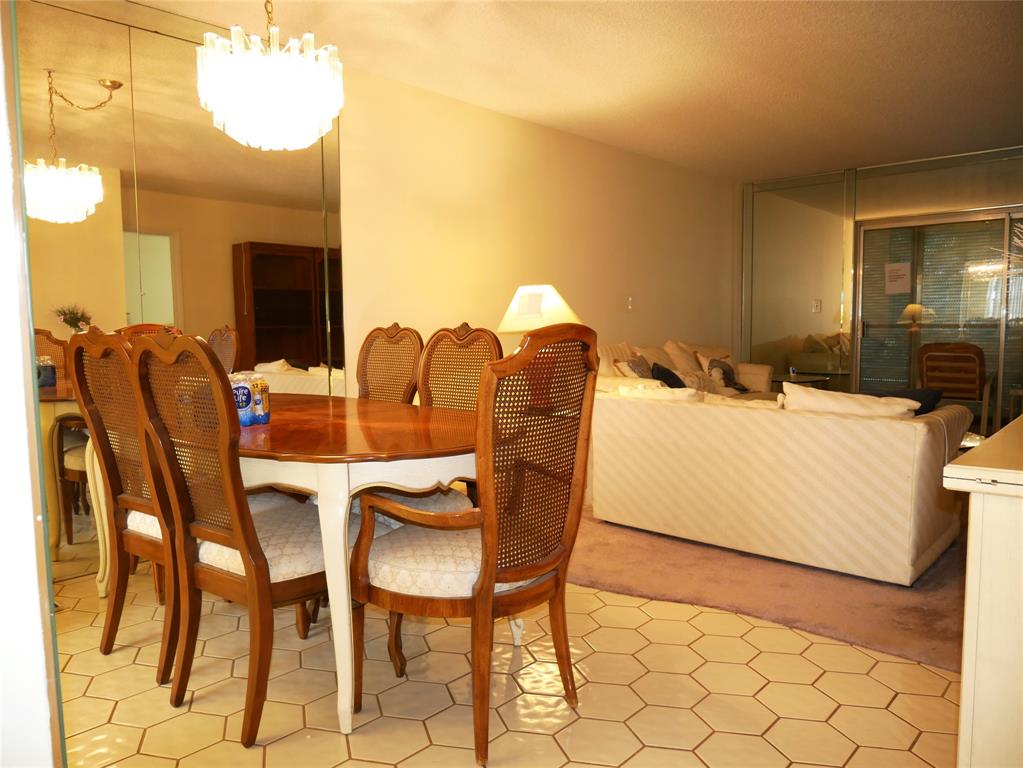 8305 Northwest 61st Street, Unit 203 Tamarac, FL 33321 - Photo 3 of 13 a dining room with furniture and a chandelier