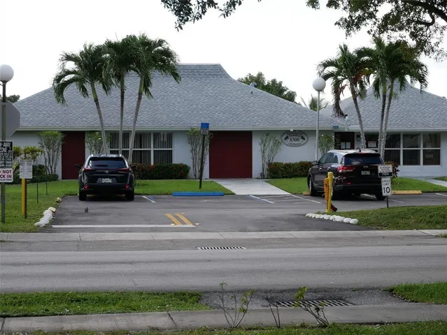 a front view of a house with a garden and trees