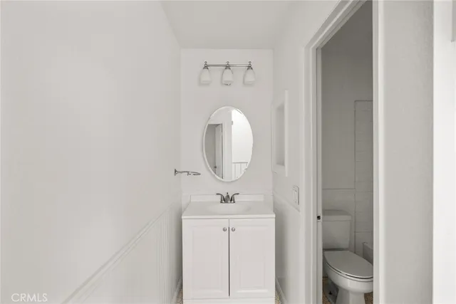 a hallway with white cabinets and chandelier