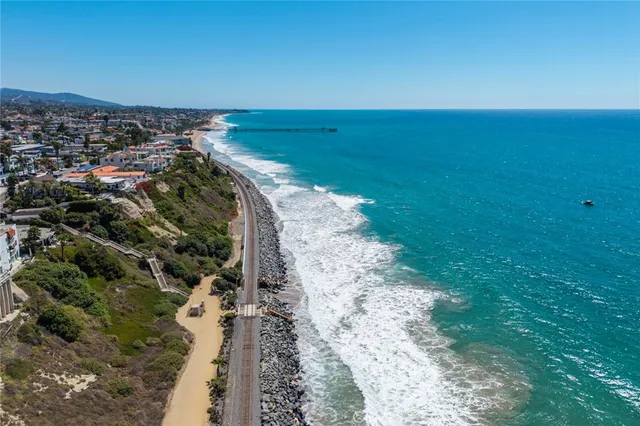 an aerial view of a city with ocean view in back