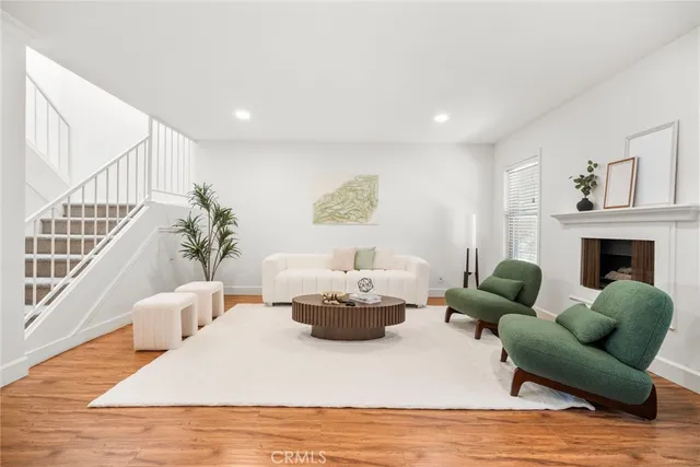 a living room with furniture a fireplace and a open kitchen view