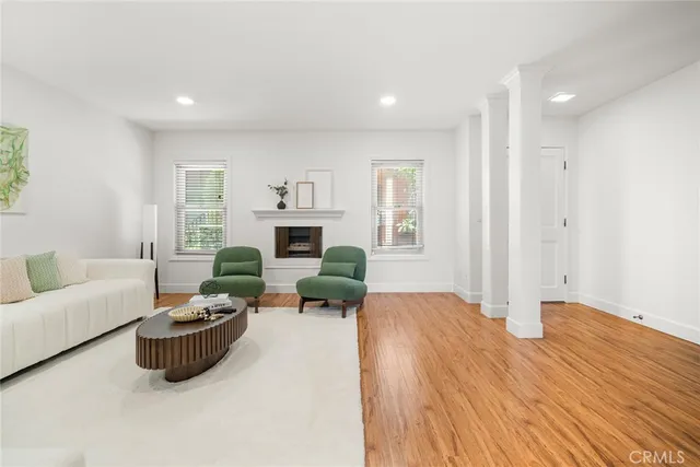 a living room with furniture a fireplace and a floor to ceiling window