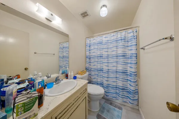 a bathroom with a sink mirror vanity and toilet