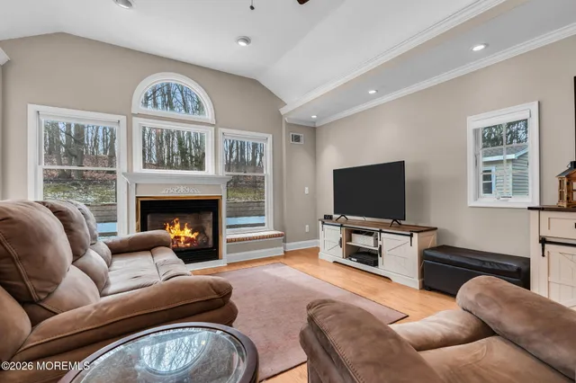 a living room with furniture a flat screen tv and a fireplace