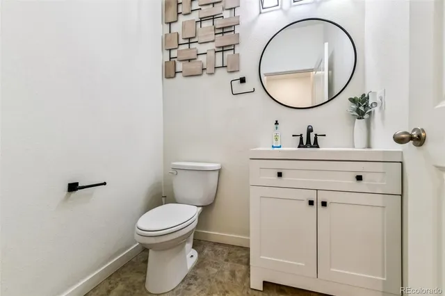 a bathroom with a toilet a sink and a mirror
