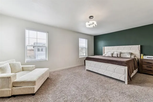 a spacious bedroom with a bed and a chandelier