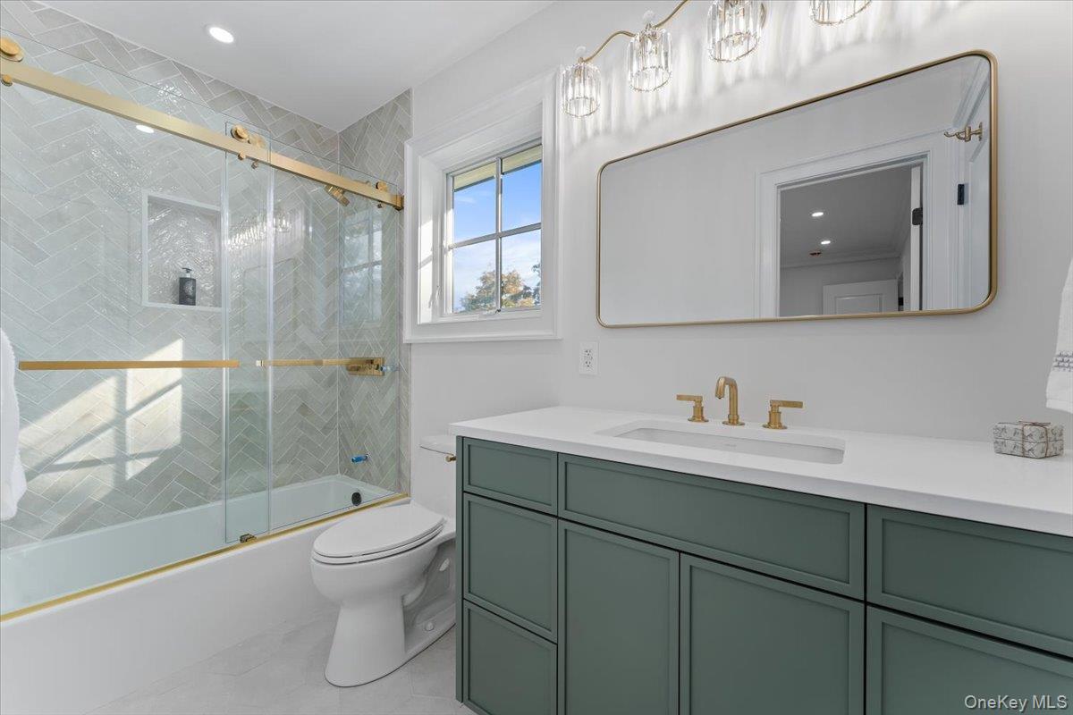 50 Franklin Avenue Rye, NY 10580 - Photo 16 of 45 a bathroom with a toilet a sink a glass door a shower a mirror and vanity