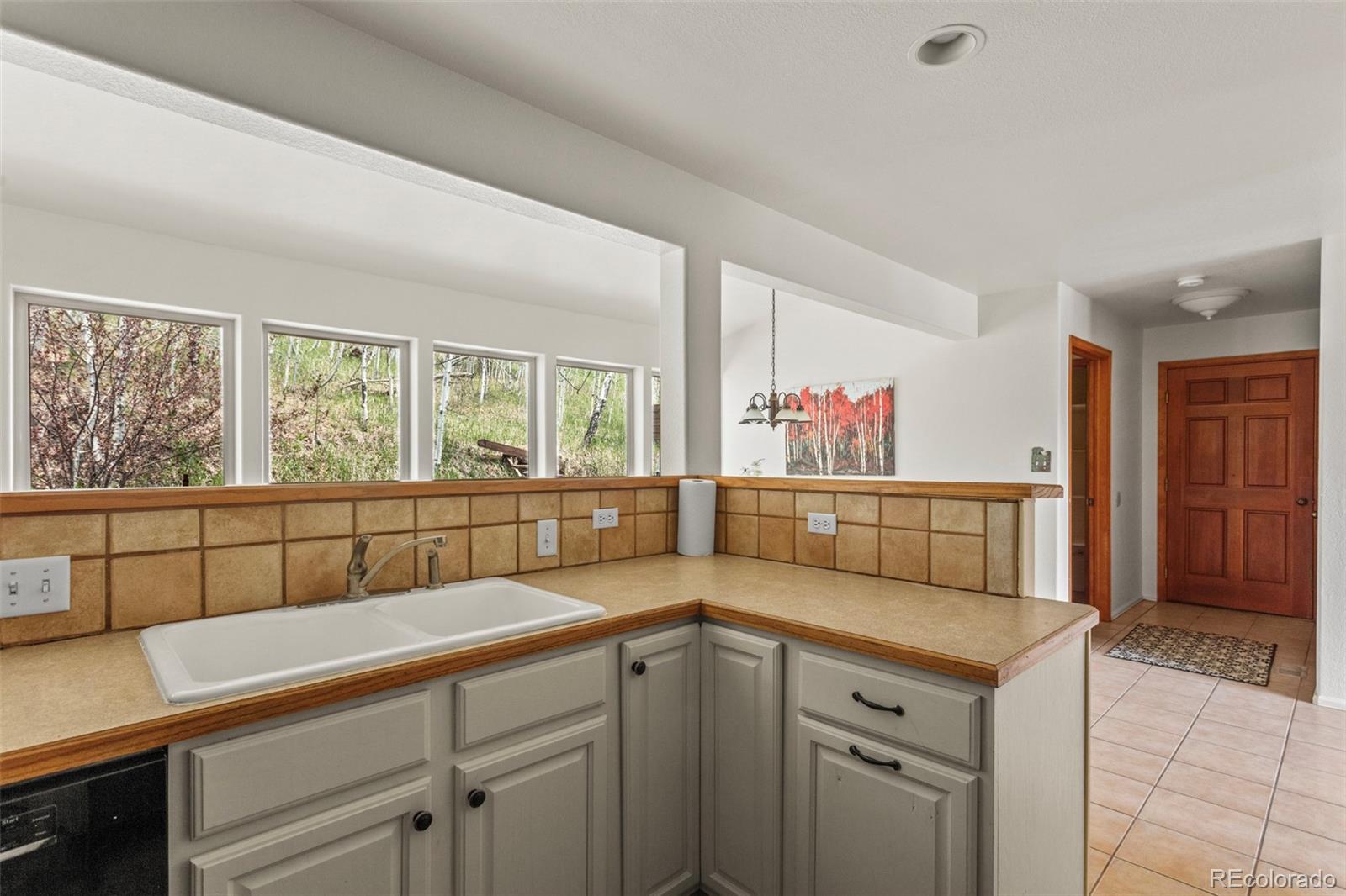 12183 Arnett Ranch Road Littleton, CO 80127 - Photo 9 of 28 a kitchen with a cabinets a sink and a window