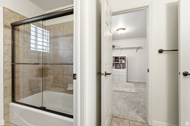 1712 Somerset Ridge Drive Draper, UT 84020 - Photo 44 of 76 Bathroom featuring a white bathtub with a bronze-framed glass shower enclosure, beige tiled walls, and a window with horizontal blinds