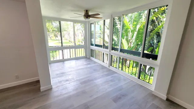 an empty room with wooden floor windows and outdoor view